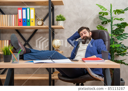 Tired guy in suit relaxing from work with legs on office desk, rest break 85113287