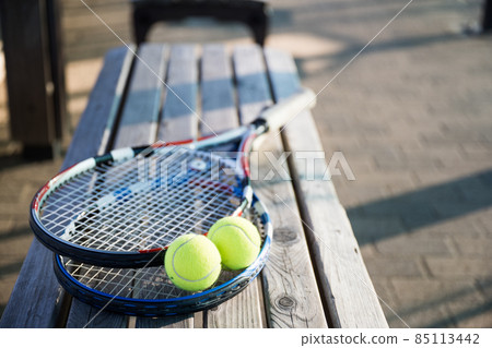 Tennis racket and ball placed on the bench on the courtside Tennis racket and ball placed on the bench on the courtside 85113442