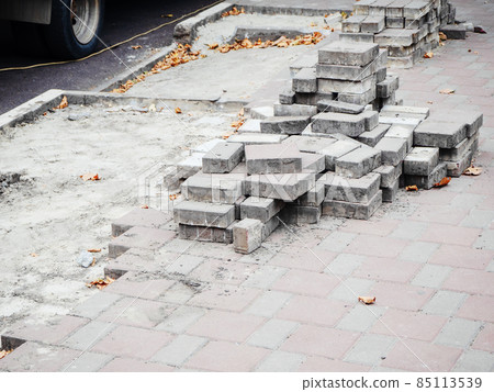 Sidewalk with not fully laid out paving slabs and stacked tiles on it Sidewalk with not fully laid out paving slabs and stacked tiles on it 85113539