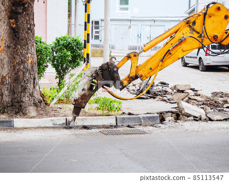 Hydraulic hammer crushing asphalt along the road in the street 85113547