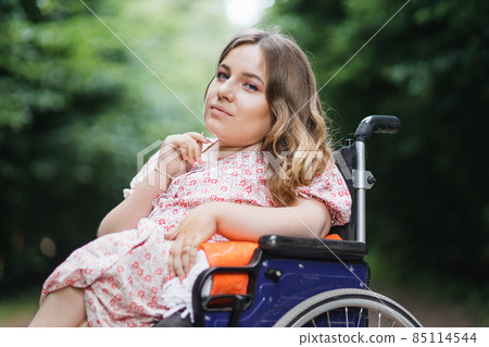Caucasian woman with disability posing at summer park Caucasian woman with disability posing at summer park 85114544