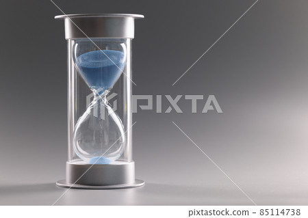 Hourglass filled with blue sand which running through tiny hole Hourglass filled with blue sand which running through tiny hole 85114738