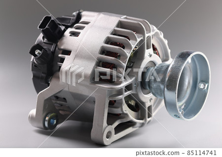 Metal motor with wire and plugs lies on grey surface, production of complex equipment Metal motor with wire and plugs lies on grey surface, production of complex equipment 85114741