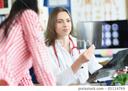 Clever professional doctor examine x ray result on appointment, show patient Clever professional doctor examine x ray result on appointment, show patient 85114769