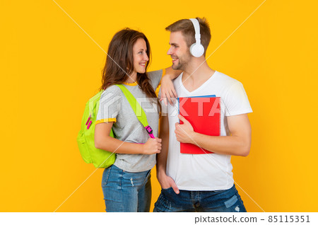 guy and girl hold notebook. university students on yellow background. study with workbook. 85115351