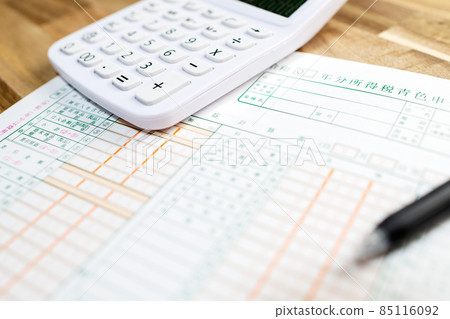 桌子上一字排開的藍色退貨單、計算器和筆 桌子上一字排開的藍色退貨單、計算器和筆 85116092