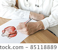 Doctor describing the heart on a clipboard in medical office 85118889