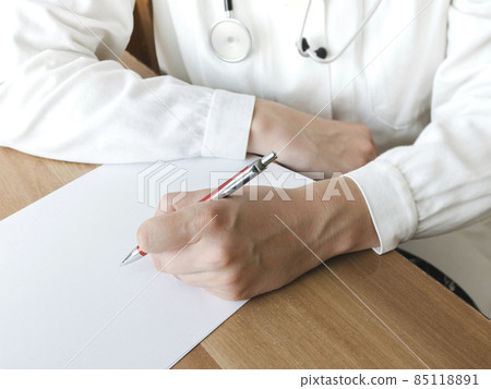 Doctor writing on a clipboard in medical office Doctor writing on a clipboard in medical office 85118891