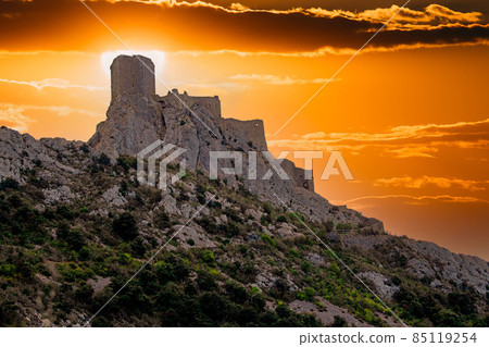 Cathar medieval fortress Queribus from the foot of the mountain in the summer. Languedoc, Occitania Cathar medieval fortress Queribus from the foot of the mountain in the summer. Languedoc, Occitania 85119254