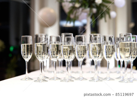 A lot of wine glasses with a champagne or white wine. . lot of glasses with champagne during on the party table. selective focus 85119697