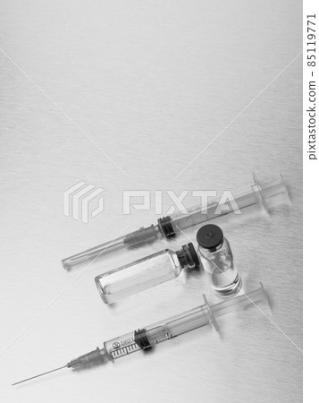 Syringes and ampoules on a polished metal background. Syringes and ampoules on a polished metal background. 85119771