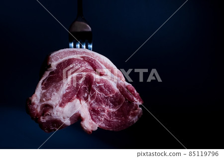 piece red raw pork neck meat on fork on dark background piece red raw pork neck meat on fork on dark background 85119796