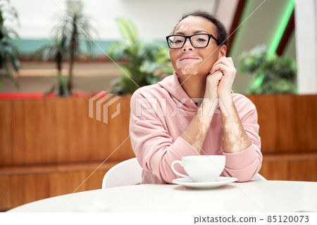 Black african american woman with vitiligo pigmentation skin problem indoor dressed pink hoodie 85120073