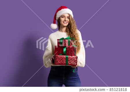 Christmas woman holds many gifts boxes on purple studio background. Christmas concept. Sales  85121818