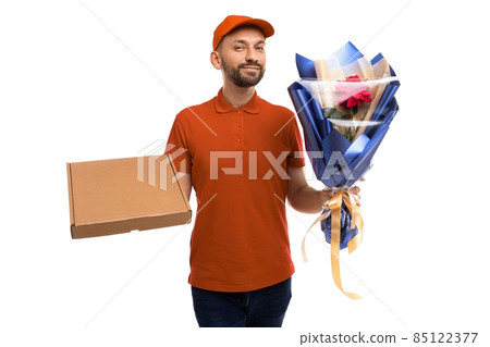 a courier in a red polo and a cap holds a bouquet and a box with a gift, Delivery Concept a courier in a red polo and a cap holds a bouquet and a box with a gift, Delivery Concept 85122377