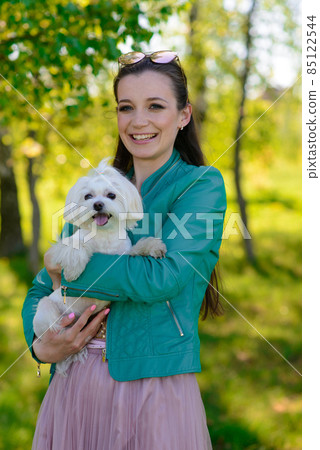 Puppy white dog with it's owner. Concept about friendship, animal and freedom. Puppy white dog with it's owner. Concept about friendship, animal and freedom. 85122544