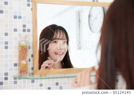 在鏡子前戴吹嘴矯正器的女人 85124145