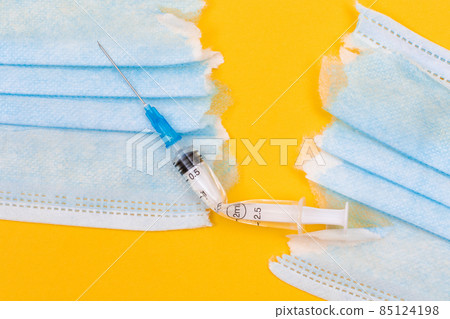 Broken Medical Syringe and Torn Medical Face Mask 85124198