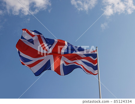 UK Great Britain flag waving in cloudy blue sky UK Great Britain flag waving in cloudy blue sky 85124334