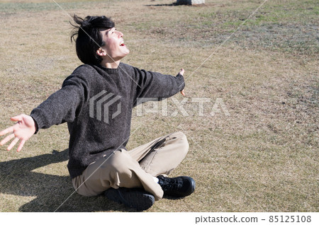 一個人在草坪上伸展 85125108