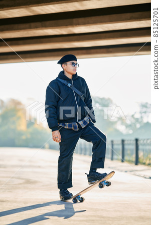 Skateboarder doing a trick on the street urban background Skateboarder doing a trick on the street urban background 85125701