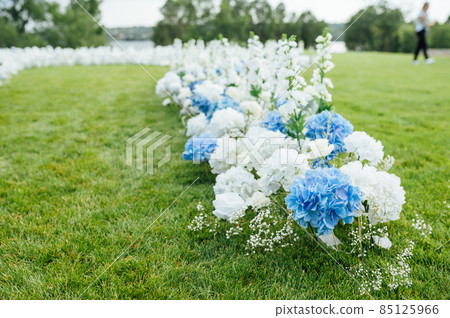 Incredibly beautiful outdoor ceremony on green grass and wooden chairs and fresh flowers. Wedding day Incredibly beautiful outdoor ceremony on green grass and wooden chairs and fresh flowers. Wedding day 85125966