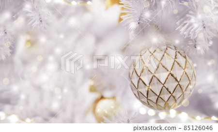 Pastel purple artificial Christmas tree with white shabby ball. White fir tree decorated with light bulbs for New Year celebration. Banner with copy space. Pastel purple artificial Christmas tree with white shabby ball. White fir tree decorated with light bulbs for New Year celebration. Banner with copy space. 85126046