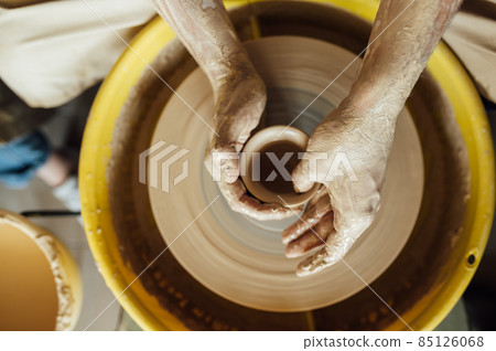 Hands of a potter. Potter making ceramic pot on the pottery wheel 85126068