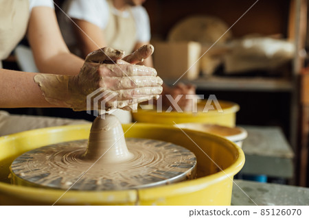 Hands of a potter. Potter making ceramic pot on the pottery wheel 85126070