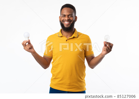 African American Guy Holding Light Bulbs Standing On White Background African American Guy Holding Light Bulbs Standing On White Background 85127006