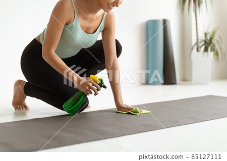 Closeup Shot Of Young Woman Cleaning Yoga Mat Surface Before Training 85127111