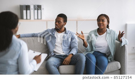 Female psychologist giving therapy session to stressed young black couple at office, panorama Female psychologist giving therapy session to stressed young black couple at office, panorama 85127154