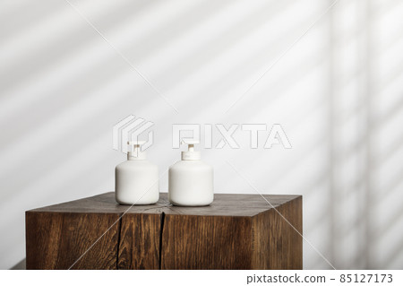 Soap and lotion white ceramic dispensers with pump on solid oak stump. Daily body care, spa and wellness zero waste bathroom concept Soap and lotion white ceramic dispensers with pump on solid oak stump. Daily body care, spa and wellness zero waste bathroom concept 85127173