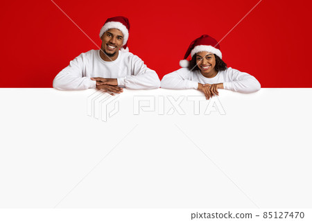 Loving black couple leaning on blank horizontal advertising board 85127470