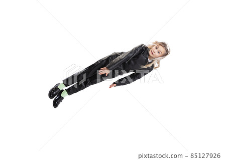 Flying cute little girl wearing black costume levitating isolated on gray studio background. Childhood, study concept 85127926