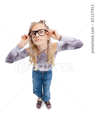 High angle view of beautiful little girl, kid in casual clothes having fun, posing isolated on gray studio background. 85127951