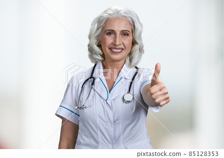 Successful senior woman doctor gesturing thumb up to camera. 85128353