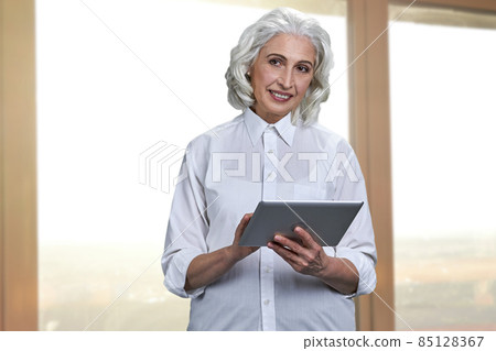 Successful senior business woman working with digital tablet pc. 85128367