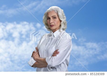 Portrait of beautiful senior woman looking at camera with crossed arms. Portrait of beautiful senior woman looking at camera with crossed arms. 85128389