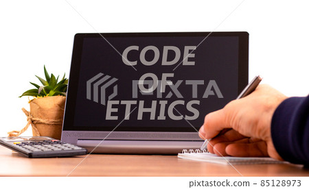 Code of ethics symbol. Tablet with words 'code of ethics'. Businessman hand with pen, house plant. Beautiful white background. Business, code of ethics concept, copy space. 85128973