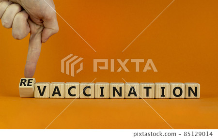 Revaccination or vaccination symbol. Turned cubes and changed the word vaccination to revaccination. Beautiful orange background, copy space. Medical, covid-19 pandemic revaccination concept. 85129014