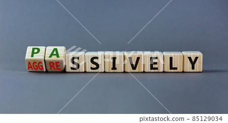 Passively or aggressively symbol. Turned wooden cubes and changed the word 'passively' to 'aggressively'. Psychological and passively or aggressively concept. Beautiful grey background, copy space. Passively or aggressively symbol. Turned wooden cubes and changed the word 'passively' to 'aggressively'. Psychological and passively or aggressively concept. Beautiful grey background, copy space. 85129034