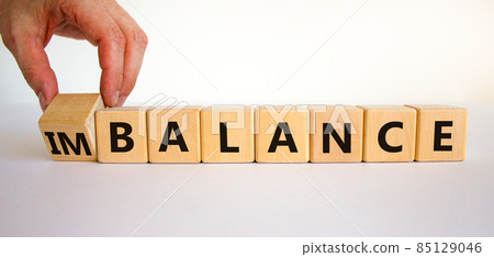 Balance or imbalance symbol. Businessman turns cubes and changes the word imbalance to balance. Beautiful white background, copy space. Business, balance or imbalance concept. Balance or imbalance symbol. Businessman turns cubes and changes the word imbalance to balance. Beautiful white background, copy space. Business, balance or imbalance concept. 85129046