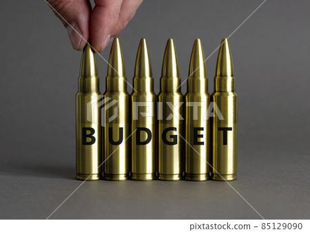 Budget symbol. Ammunitions imitation with the word BUDGET. Beautiful grey background, copy space. Business and budget concept. Budget symbol. Ammunitions imitation with the word BUDGET. Beautiful grey background, copy space. Business and budget concept. 85129090