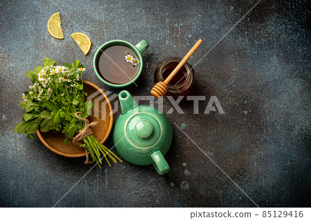Herbal tea with natural healing medical herbs, tea cup, tea pot top view Herbal tea with natural healing medical herbs, tea cup, tea pot top view 85129416
