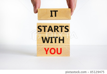 It starts with you symbol. Concept words It starts with you on wooden blocks. Businessman hand. Beautiful white table, white background, copy space. Business and It starts with you concept. 85129475