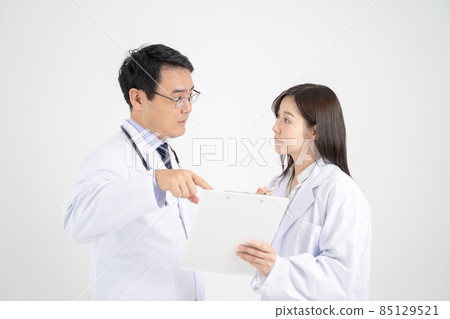 Male and female doctors consulting in medical records, white background Male and female doctors consulting in medical records, white background 85129521