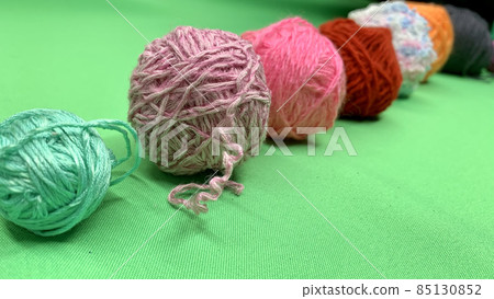 Multi-colored threads for knitting lie on the chromakey table 85130852