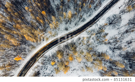 Aerial high angle view of narrow curvy road. Aerial high angle view of narrow curvy road. 85131631