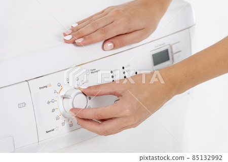 woman programming washing machine. High quality photo 85132992